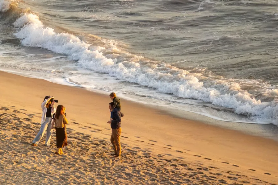 A family posing for portraits on the beach at golden hour