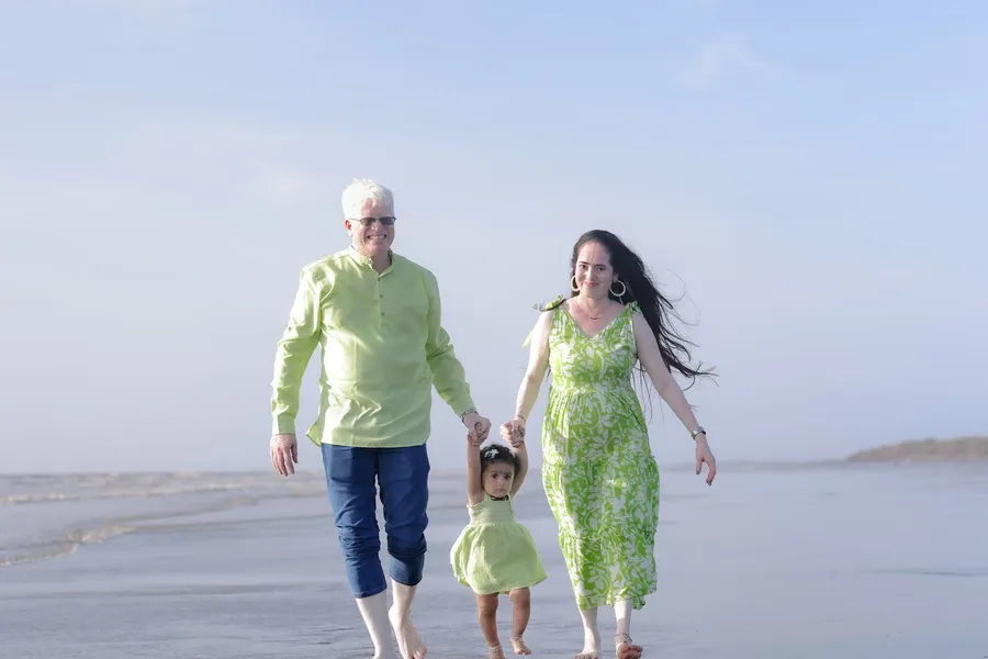 A family strolling barefoot along the shoreline