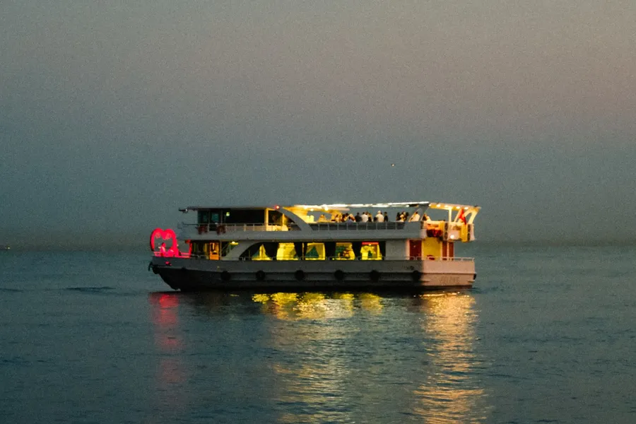 Sightseeing cruise boat glowing at dusk on calm water