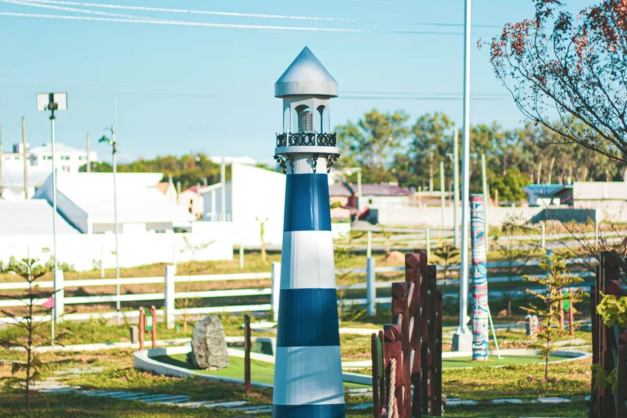 A mini golf course with a lighthouse obstacle
