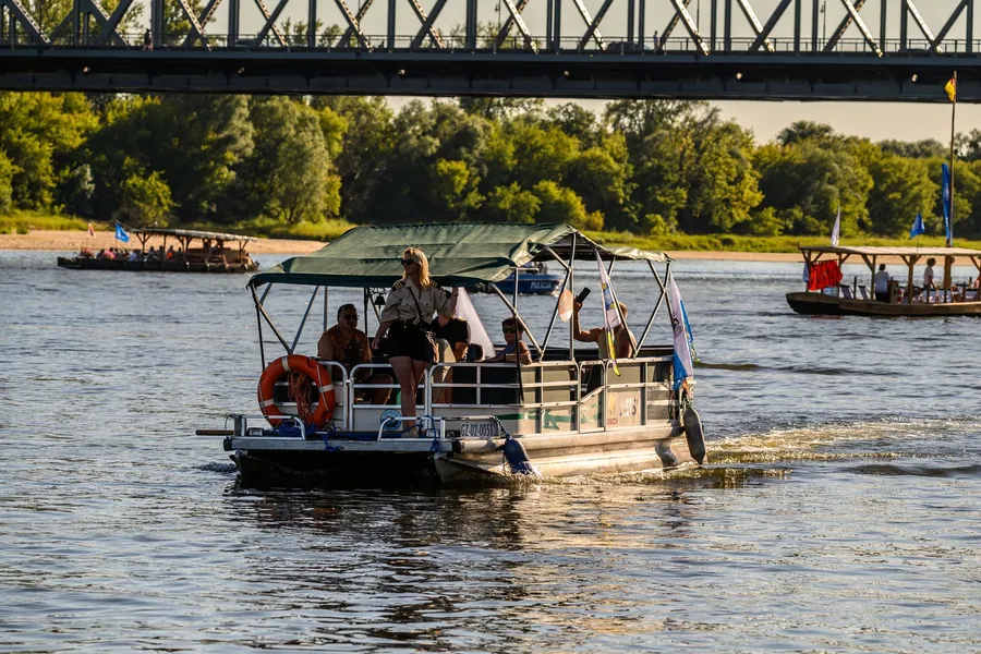 A pontoon boat cruising with passengers on a sunny day