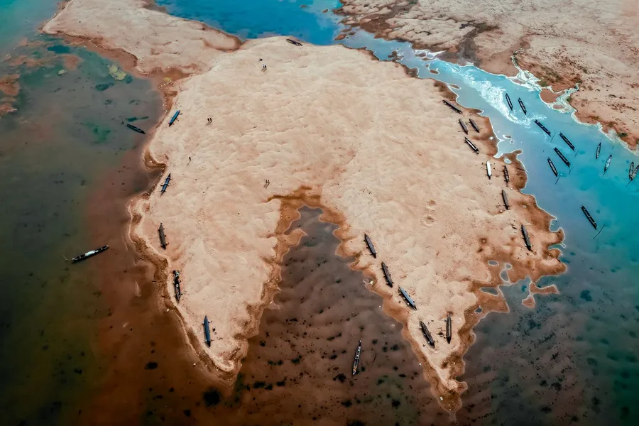 Aerial view of boats anchored around a shallow sand island